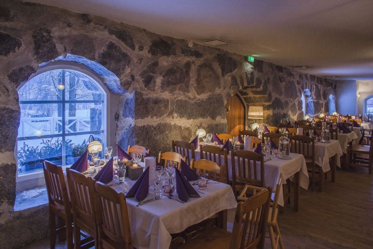 Kuva: VisitLahti.fi Pyhäniemen kartanonen keltainen päärakennus, etualalla vihreä nurmi ja puiston puita.